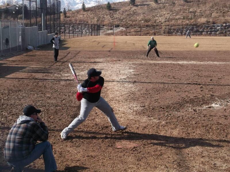 Two teams battle on the muddy diamond of Quarry Bend Park during the first round of Sandy's Snowball Softball Tournament.