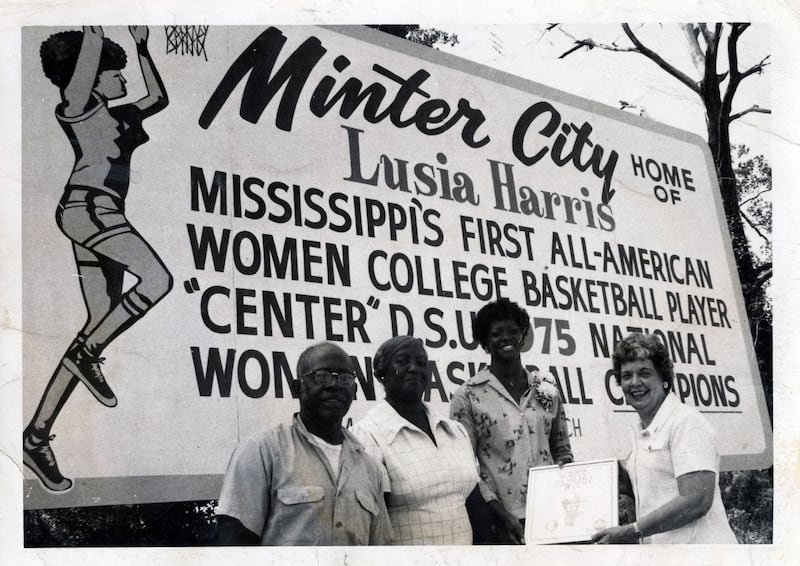 Lusia Harris, second from right, the first and only player ever selected in the NBA draft, poses in front of a billboard honoring her college basketball accomplishments.