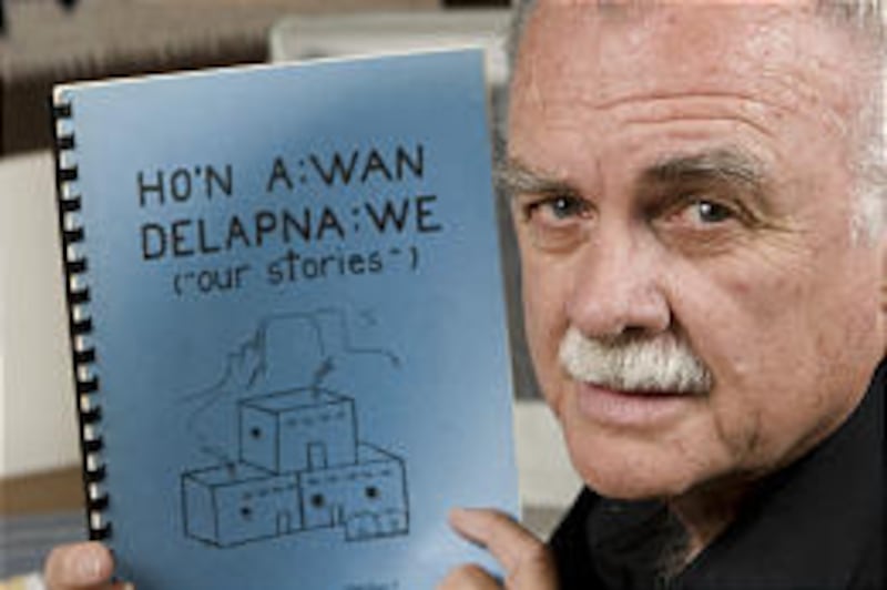 Curtis Cook holds a Zuni children's storybook. Cook helped save Zuni Indian oral history by preserving it in writing.