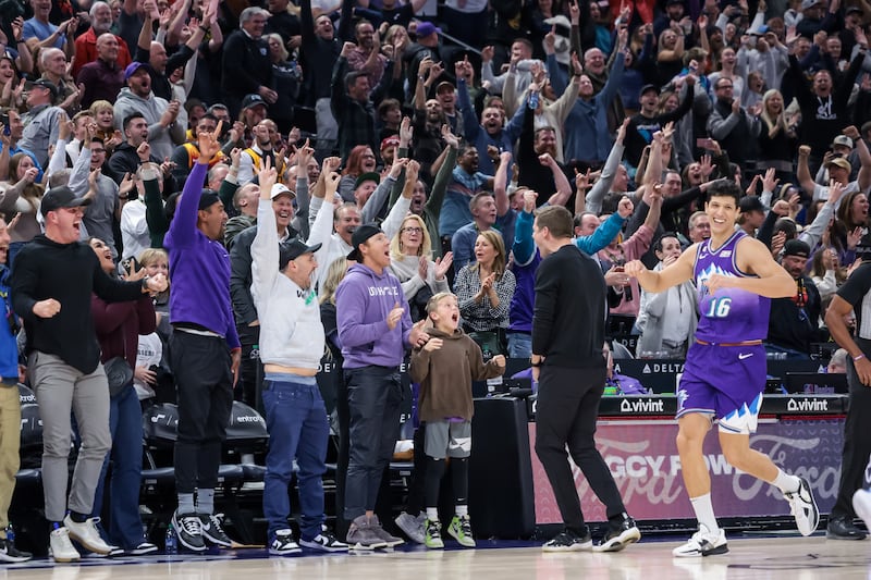 Utah Jazz owner Ryan Smith, center, head coach Will Hardy, forward Simone Fontecchio (16) and fans celebrate after the team’s win over the Golden State Warriors at Vivint Arena in Salt Lake City on Wednesday, Dec. 7, 2022.