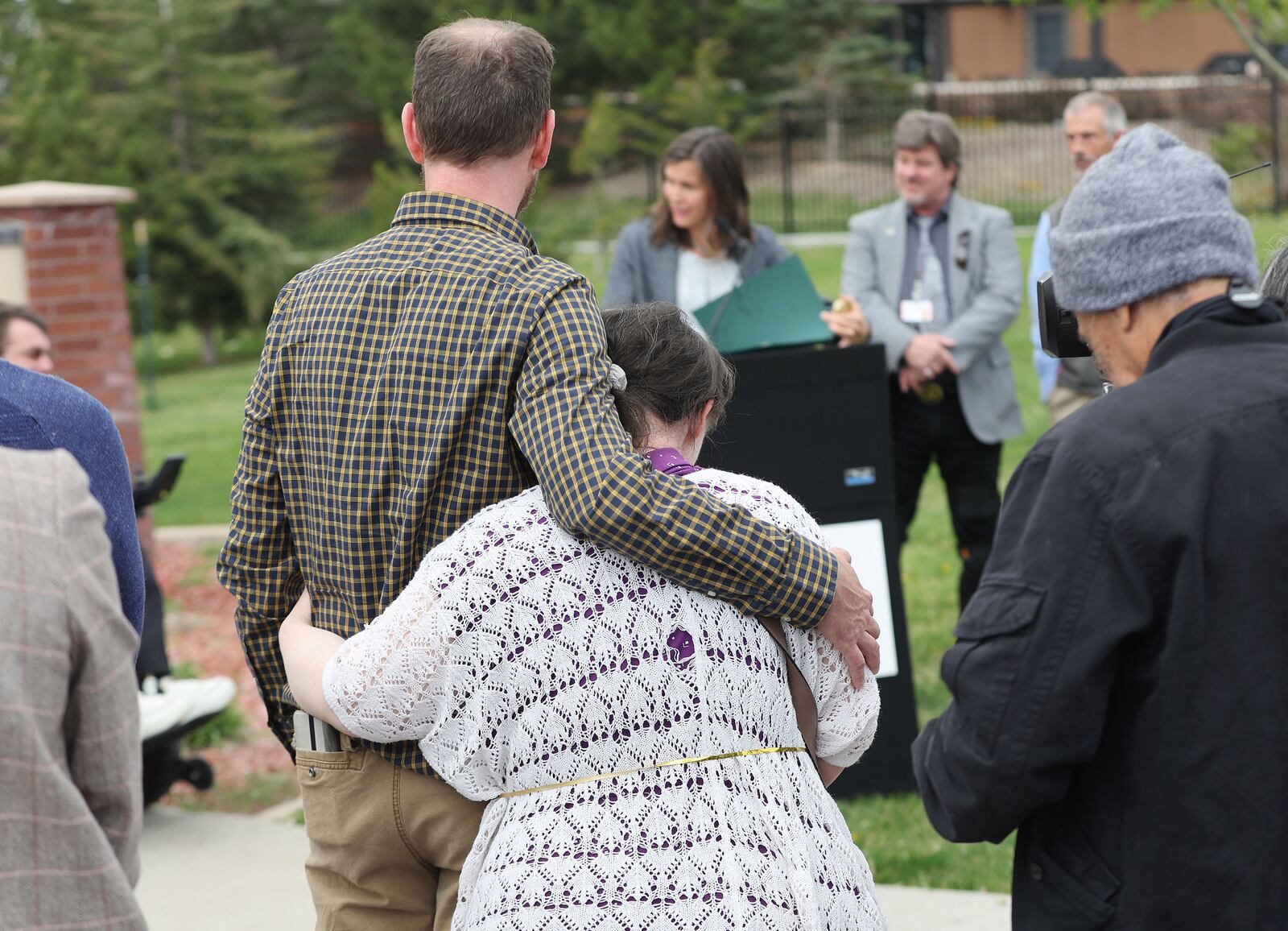 Vard McGuire hugs his sister, Mindy McGuire, as Salt Lake City Mayor Erin Mendenhall reads a proclamation about fair housing.
