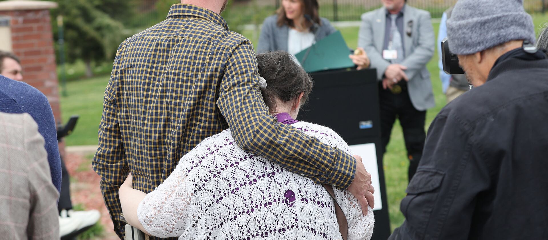 Vard McGuire hugs his sister, Mindy McGuire, as Salt Lake City Mayor Erin Mendenhall reads a proclamation about fair housing.