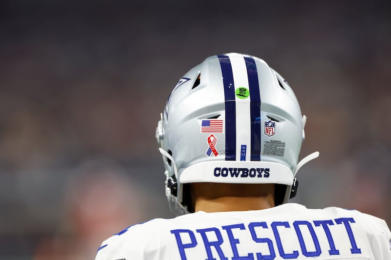 Photo of Dallas Cowboys quarterback Dak Prescott from the back showing the American flag decal on his helmet