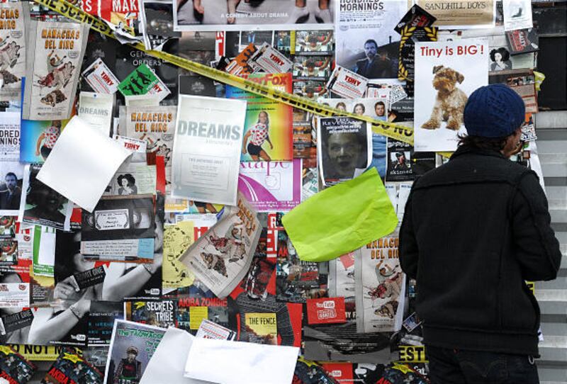 A festivalgoer looks at a billboard of movie posters during the Sundance Film Festival in Park City.