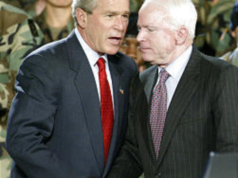 President Bush talks to Sen. John McCain after McCain introduced him at a Fort Lewis, Wash., rally on Friday.
