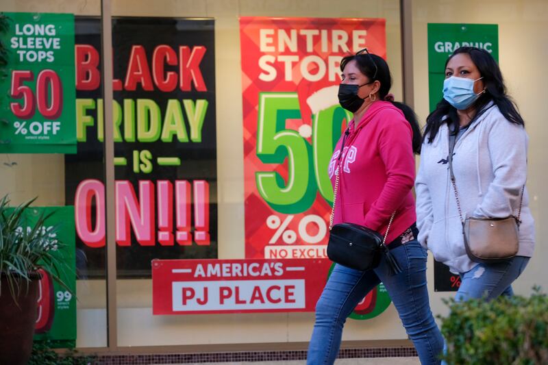 Black Friday shoppers wearing face masks shop at the Citadel Outlets in Commerce, Calif., Nov. 26, 2021.
