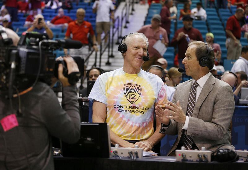 In this March 11, 2016 photo, analyst Bill Walton, left, speaks with play-by-play announcer Ted Robinson before a Pac-12 conference tournament game in Las Vegas. A Walton-called basketball game is like performance art, viewers left buzzing and maybe a lit