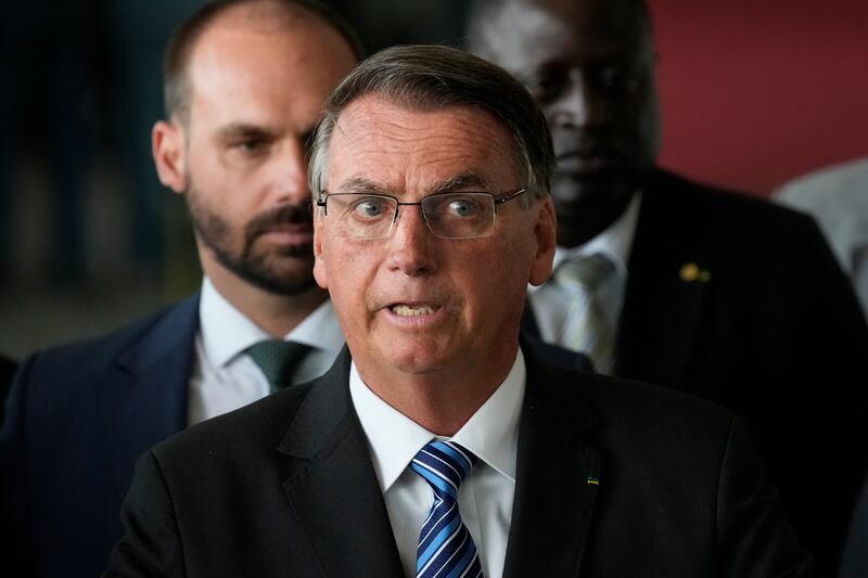 Brazilian President Jair Bolsonaro speaks from his official residence of Alvorada Palace in Brasilia, Brazil. Behind iis Bolsonaro’s son Eduardo.