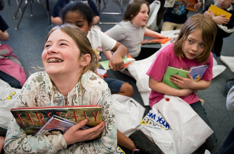 Kindal Ross, left, and Mackenzie Dupuis, both fifth-graders at Borah Elementary School in Coeur d'Alene, Idaho, cradle two of the three books they and more than 40 other students received Thursday, April 9, 2009, during CDA 4 Kids after-school program. T
