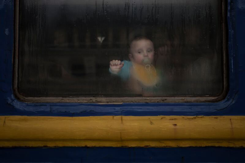 A baby sits with his mother inside a train leaving the Lviv railway station, in Lviv, west Ukraine, Wednesday, March 2, 2022.