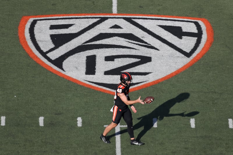 Oregon State long snapper Dylan Black warms up near a Pac-12 logo on the field at Reser Stadium.