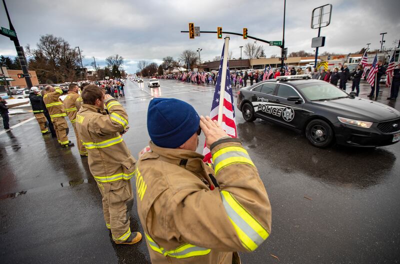 Mapleton firefighters salute as thousands line 400 South and Main Street in Springville as the body of slain Provo police officer Joseph Shinners is escorted to a funeral home during a processional on Sunday, Jan. 6, 2019.