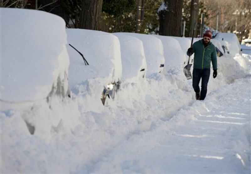 Ben Osborn walks with a shovel past a line of snowed-in cars A Steet in northeast Washington, Sunday, Jan. 24, 2016. Washington is digging out after a mammoth blizzard with hurricane-force winds and record-setting snowfall brought much of the East Coast t