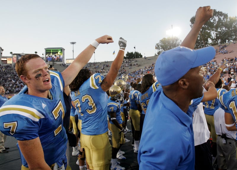 UCLA quarterback Ben Olson, left, and head coach Karl Dorrell, right, celebrate the Bruins' 27-17 victory over BYU in Pasadena, Calif., on Saturday, Sept. 8, 2007.