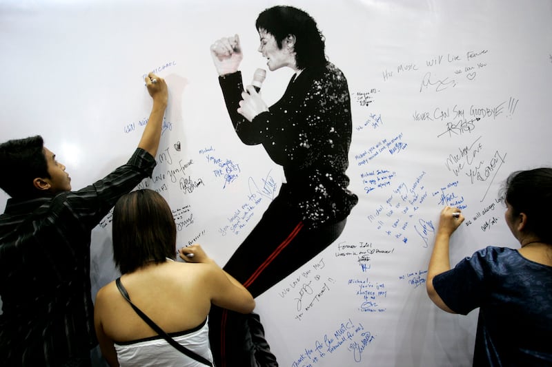 Fans write condolence notes beside Michael Jackson portrait during a rally in memory of him in Kuala Lumpur, Malaysia, June 28, 2009.