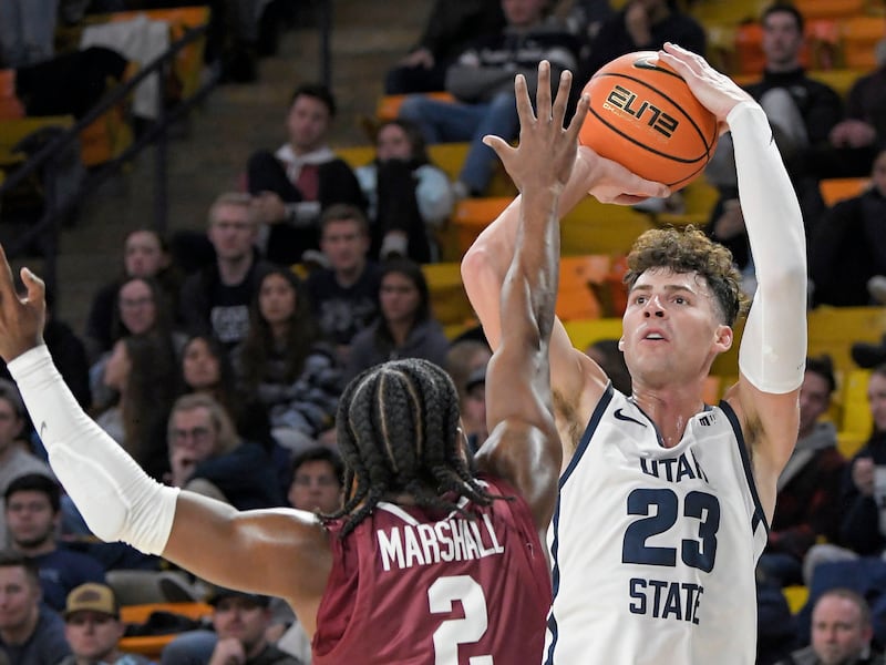 Utah State forward Taylor Funk (wearing white) looks to shoot as Santa Clara guard Carlos Marshall Jr. defends