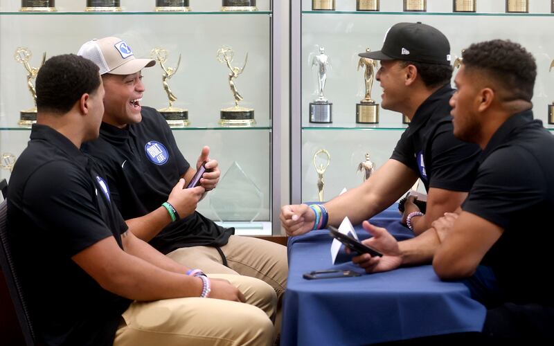 BYU running back Lopini Katoa, back left, laughs while chatting with teammates during BYU football media day.