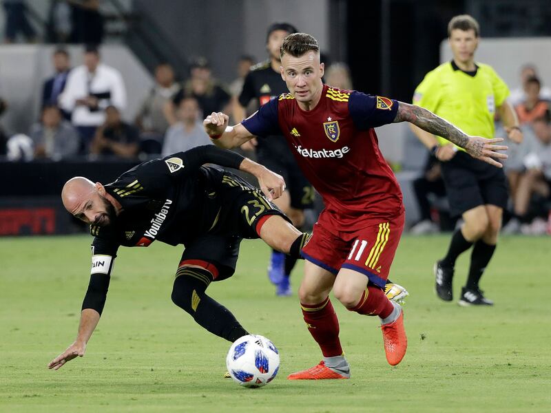 Real Salt Lake midfielder Albert Rusnak (11) dribbles past Los Angeles FC defender Laurent Ciman (23) during the first half of an MLS soccer match Wednesday, Aug. 15, 2018, in Los Angeles. (AP Photo/Marcio Jose Sanchez)