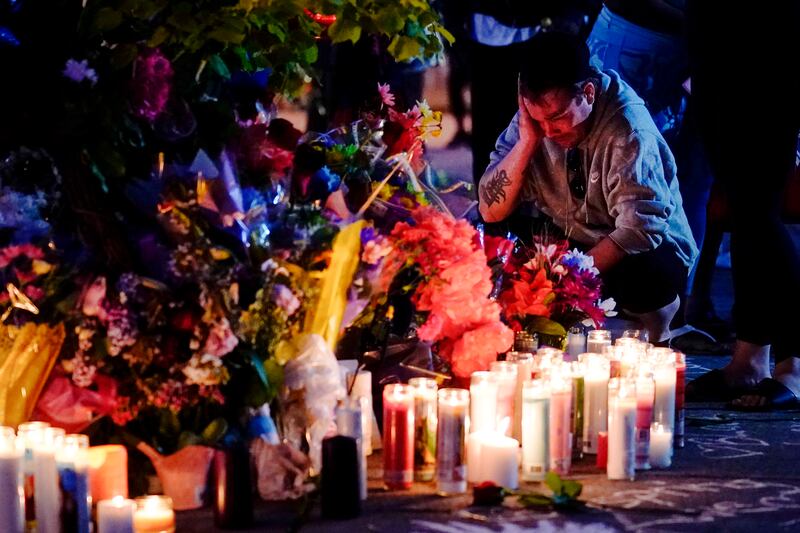 A person pays his respects outside the scene of a shooting at a supermarket, in Buffalo, N.Y., Sunday, May 15, 2022.