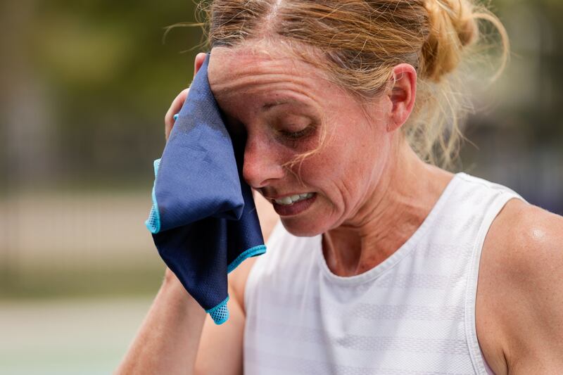 Deyce Peterson, of Heber City, wipes her face after playing tennis at Liberty Park in Salt Lake City on Tuesday, July 12, 2022.