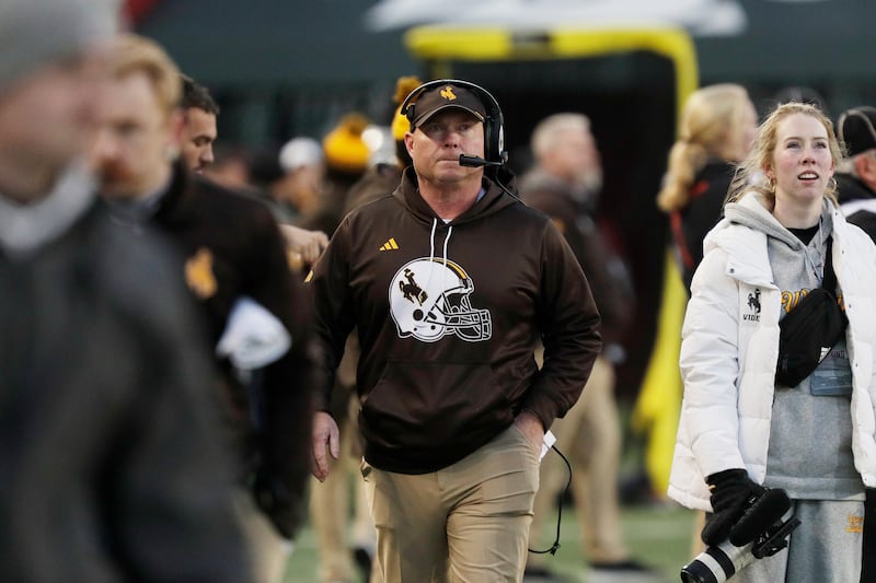 Wyoming head coach Jay Sawvel, center, walks on the sideline during the first half of a game against Washington State, Saturday, Nov. 30, 2024, in Pullman, Wash.
