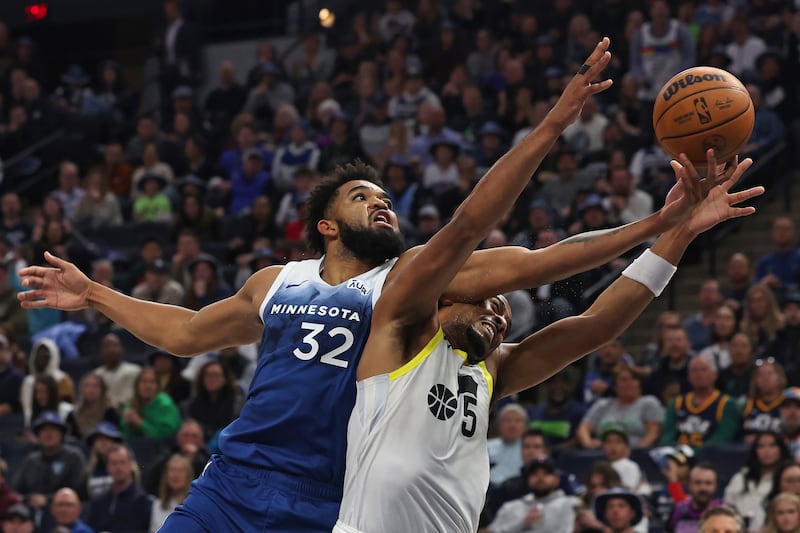Minnesota Timberwolves center Karl-Anthony Towns (32) fights for the ball against Utah Jazz guard Talen Horton-Tucker (5) during the second half of an NBA basketball game Saturday, Nov. 4, 2023, in Minneapolis. (AP Photo/Stacy Bengs)