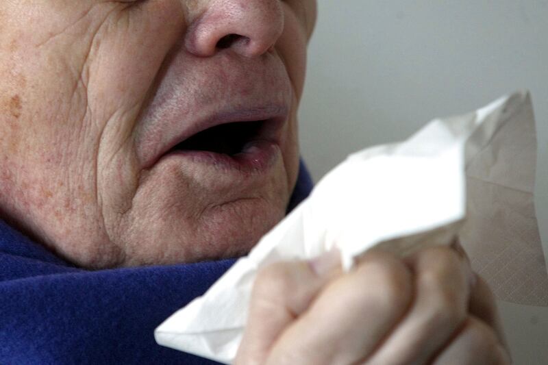 A man sneezes holding a tissue in Berlin, Germany.