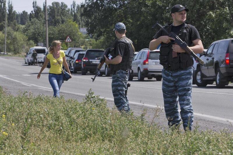 Self-proclaimed Donetsk People's Republic policemen guard a convoy of international forensic experts, Dutch and Australian policemen and members of the Organization for Security and Cooperation in Europe mission in Ukraine, as it approached Shakhtarsk, Do