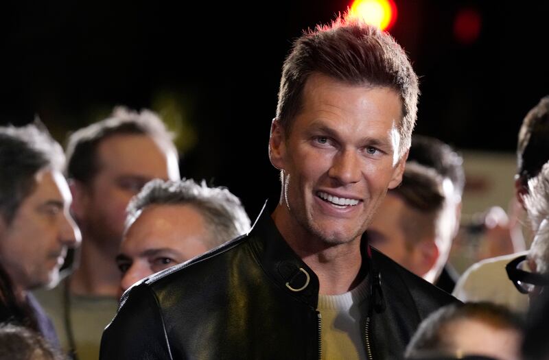 Tom Brady looks down the red carpet at the premiere of “80 for Brady.”