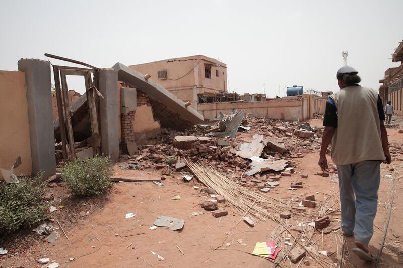 A man walks by a house hit in recent fighting in Khartoum, Sudan.