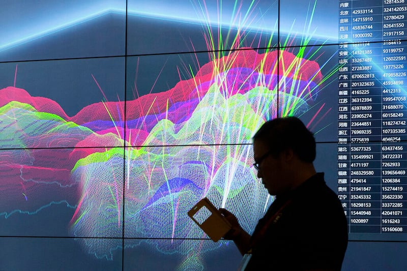 An attendee walks past a live visualization of internet attacks across China.