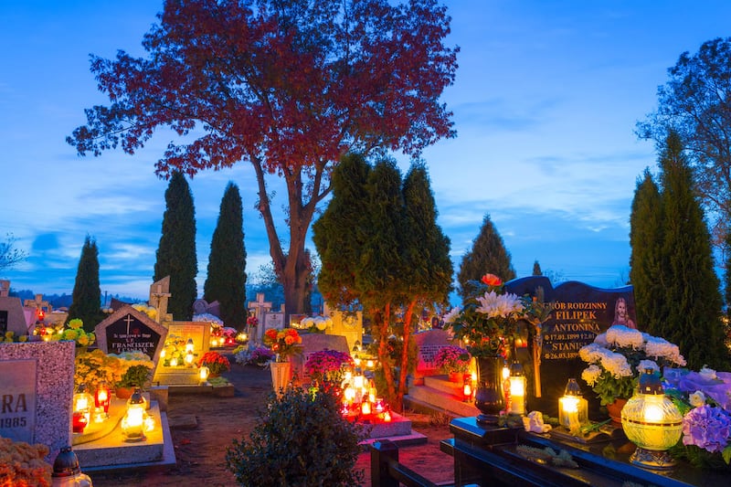 A cemetery at night with colorful candles for All Saints Day in Poland in 2014. All Saints' Day is a solemnity celebrated on  Nov. 1 by the Catholic Church.