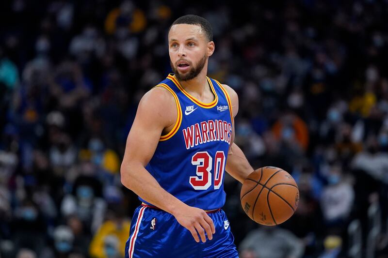 Golden State Warriors guard Stephen Curry brings the ball up against the Denver Nuggets.