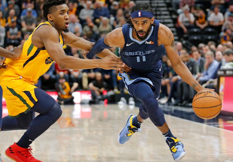 Memphis Grizzlies guard Mike Conley (11) drives around Utah Jazz guard Donovan Mitchell, left, in the first half of an NBA basketball game Monday, Oct. 22, 2018, in Salt Lake City. (AP Photo/Rick Bowmer)
