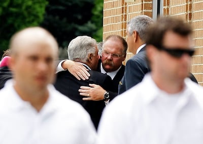 Philladephia Eagles coach Andy Reid, center, is embraced after the funeral for his son Garrett Reid, Tuesday, Aug. 7, 2012, in Broomall, Pa. Reid, 29, was found dead Sunday morning, Aug. 5, in a dorm room at the team's Lehigh University NFL football train