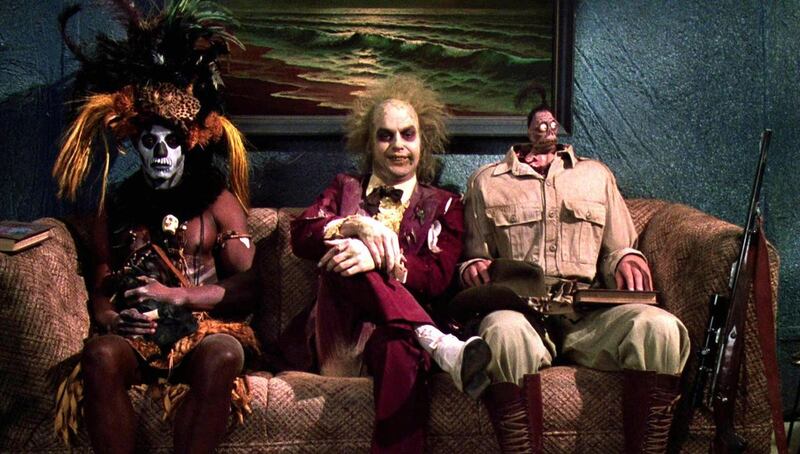 An obnoxious demonic spirit named Betelguese (Michael Keaton, center) tries to strike up a conversation with the occupants in the “afterlife waiting room” in “Beetlejuice.”