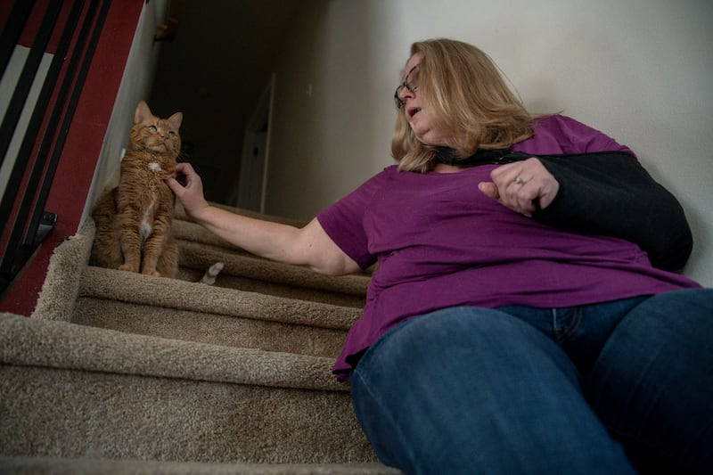 Meg Jackson-Drage plays with Ms. Ginger, her cat, at her home in Magna on Feb. 4, 2022. After her share of the monthly cost of her medicines rose to $2,000 a month, she became active in efforts to curb drug prices.