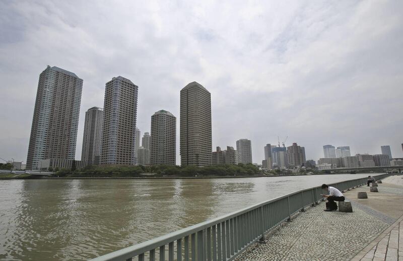 People rest at the side of Sumida River in Tokyo, Monday, June 9, 2014. Japan's parliament has passed a law which bans possession of child pornography, but excludes sexually explicit depictions of children in comics, animation and computer graphics.