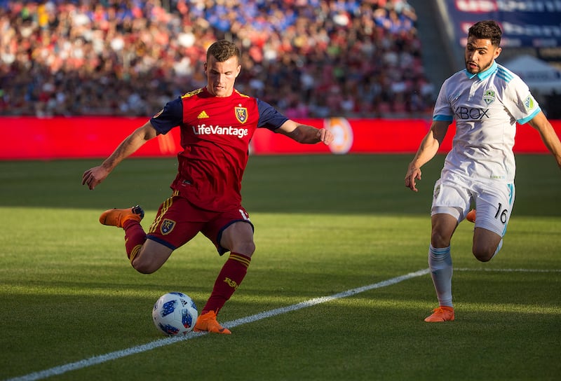 Real Salt Lake's Brooks Lennon (12) crosses the ball on the Seattle Sounders' Alex Roldan (16) at Rio Tinto Stadium in Sandy on Saturday, June 2, 2018.