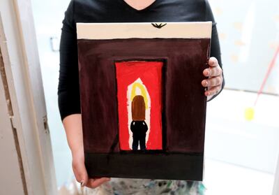 Christine, who struggles with anxiety, holds one of her paintings, called "Girl in the Mirror," at home in Murray on Friday, May 18, 2018. Painting helps her express her emotions.