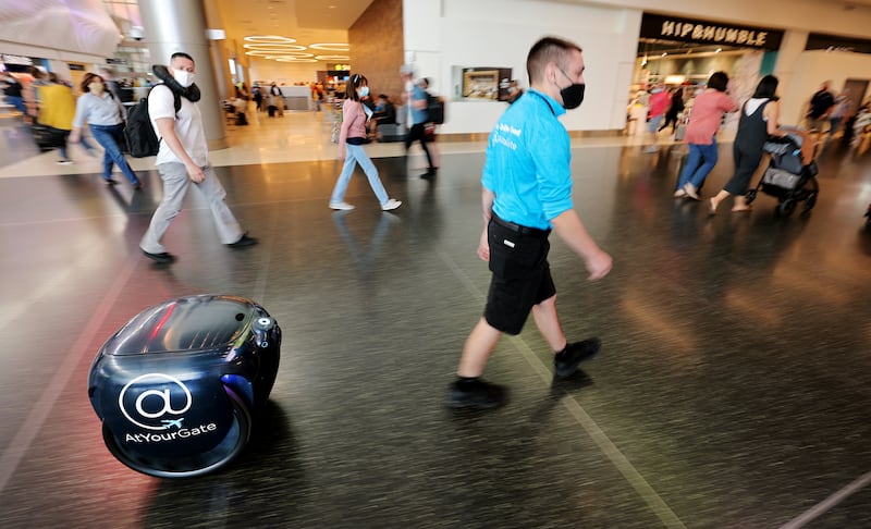 Gehry Wiesner demonstrates how Gita, a robot that delivers contact-free meal orders, works at the new Salt Lake airport.