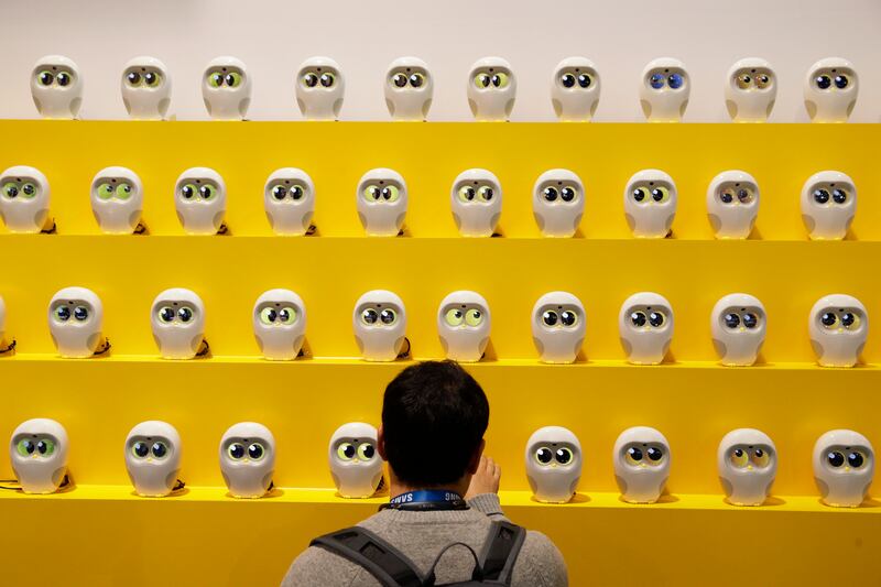 An attendee looks at book reading robots called Luka at CES International Tuesday, Jan. 9, 2018, in Las Vegas.