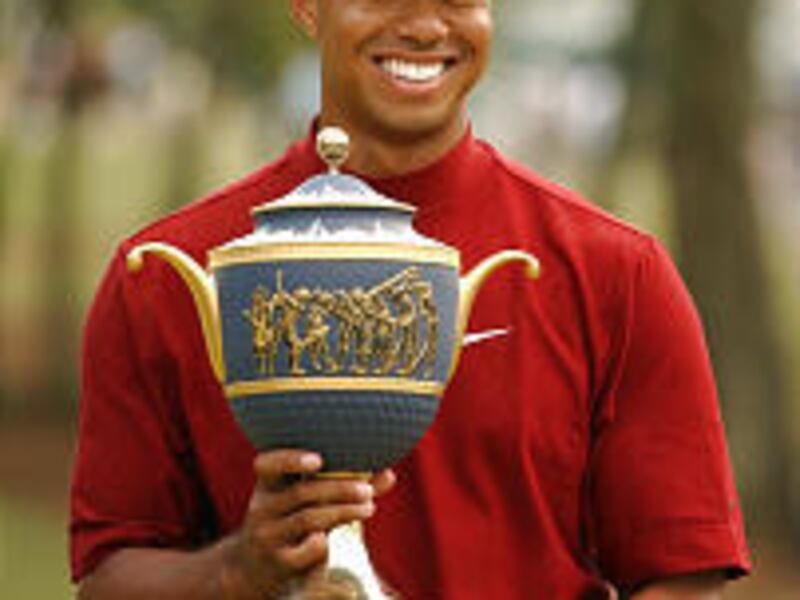 Tiger Woods holds Gene Sarazen Cup after winning American Express Championship.