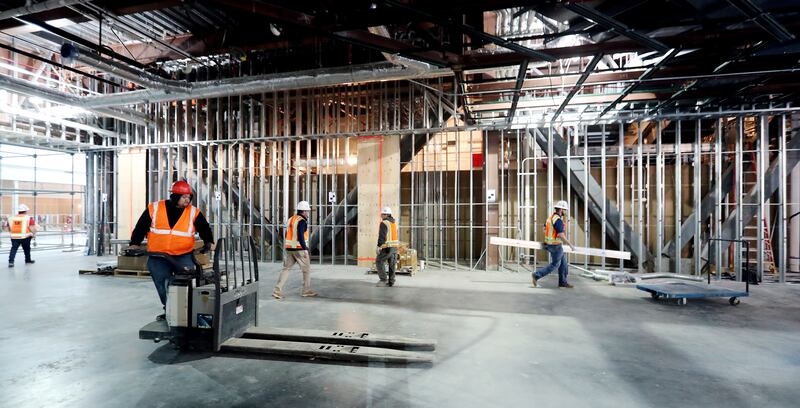 Workers remove construction materials from in front of a large wall that is being built for an art piece inside the new terminal at the Salt Lake City International Airport in Salt Lake City on Thursday, April 4, 2019. Artists are being sought to create a