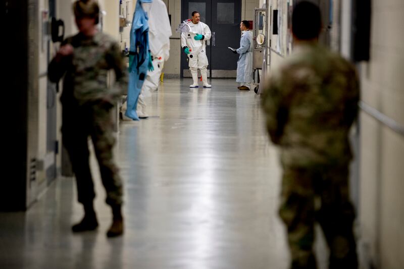 Biological science specialists, background, wear biosafety protective clothing for handling viral diseases at U.S. Army Medical Research and Development Command at Fort Detrick.