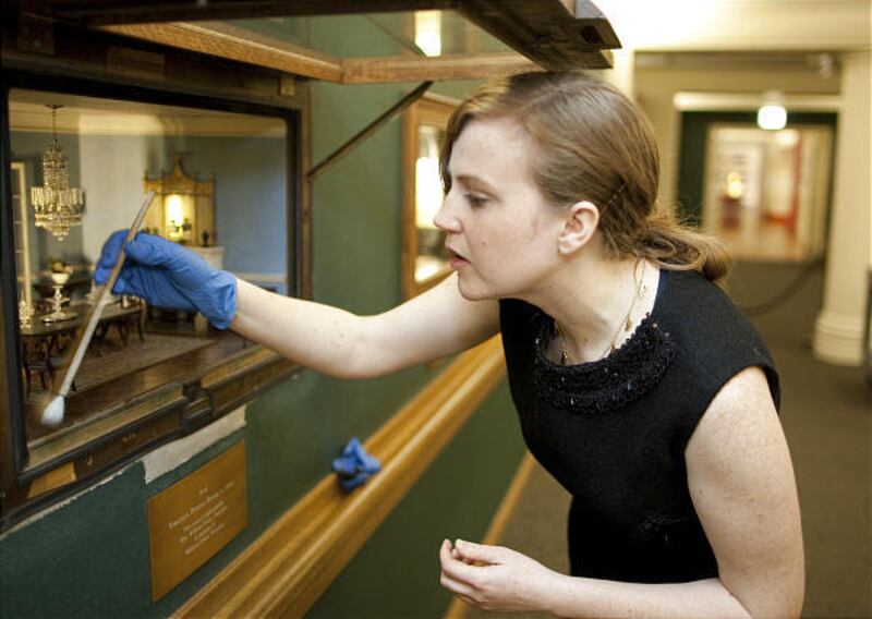 Lindsay Mican Morgan, Art Institute of Chicago's miniature exhibit curator, cleans some dust off one of the cases.