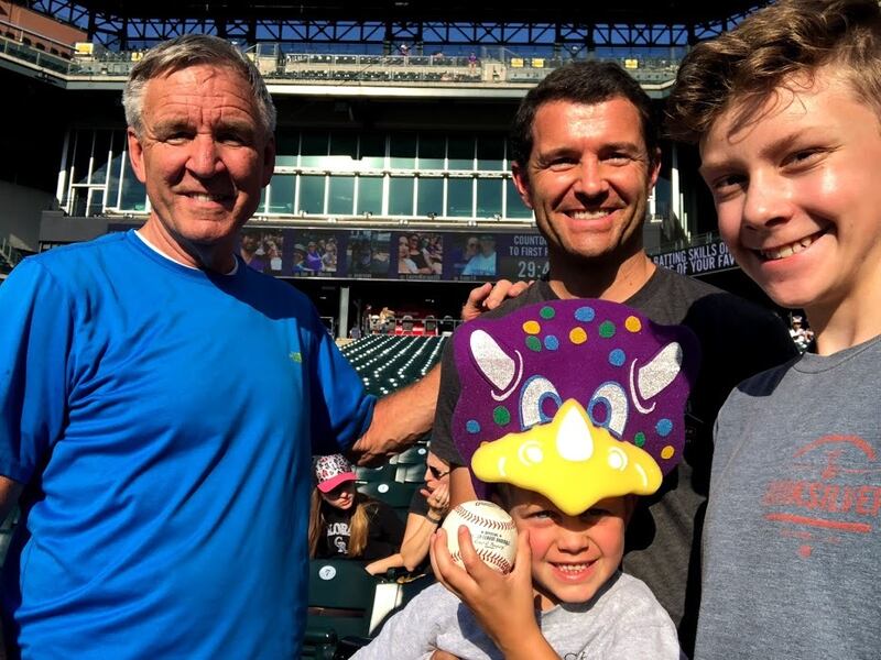 We took this selfie on arrival at Coors Field after Jack got a Dinger the Dinosaur mask at the gate and a souvenir baseball from a friendly groundskeeper.
