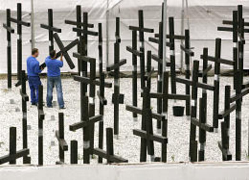 Workers remove wooden crosses near the former Checkpoint Charlie in Berlin, fulfilling a court order to dismantle a private memorial to 1,065 people killed at the East German border. The owners had refused to remove it after their lease expired. Locals an