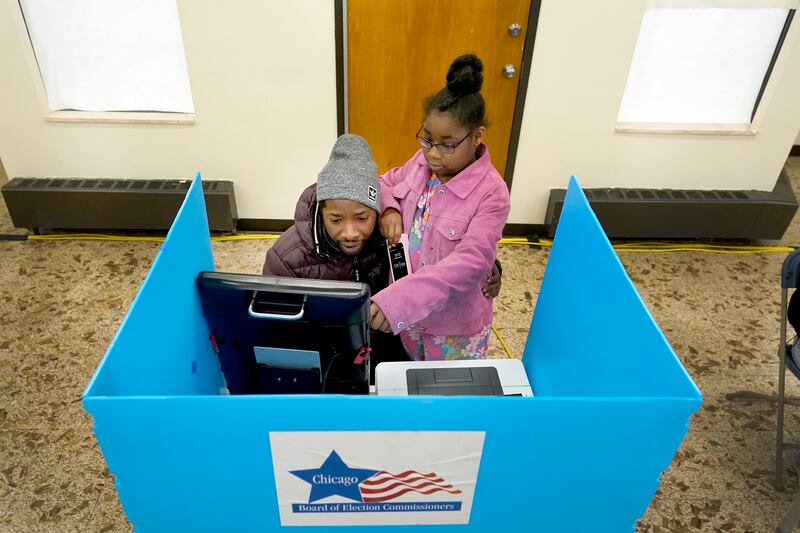 Christopher Sandridge teaches his daughter Christina the voting process at the Rev. Dr. Martin Luther King Community Center, Tuesday, Nov. 8, 2022.