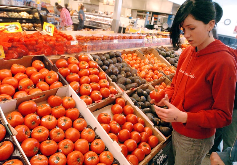 Sammy Kern shops for a tomato in the produce department of Smith’s Marketplace in Salt Lake City, Utah.